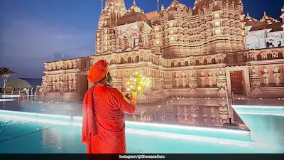Ganga Aarti ritual by the waterfront pool with illuminated BAPS Hindu Mandir in Abu Dhabi UAE